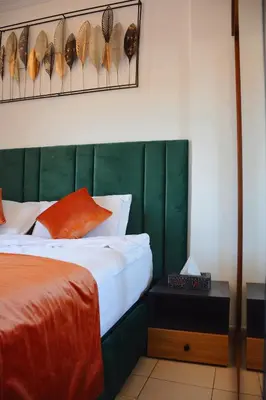 a bedroom with a bed with a green headboard at Stylish Moroccan Apartment Near Majorelle Garden, Wi-Fi, Free Airport Shuttle in Marrakech