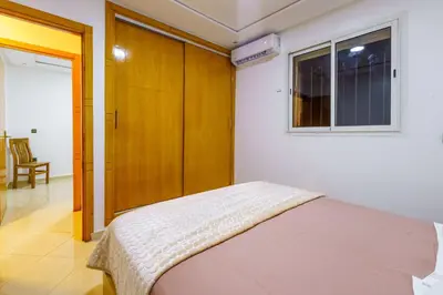 a bedroom with a bed with a wooden closet at Appartement Cosy et calme in Marrakech