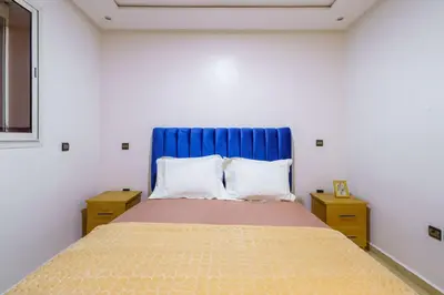 a bed with a blue headboard in a bedroom at Appartement Cosy et calme in Marrakech