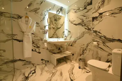 a marble bathroom with a sink and a toilet at 555 Hotel Clubbing Adults Only in Marrakech