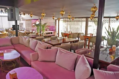 a restaurant with pink couches and tables and chairs at 555 Hotel Clubbing Adults Only in Marrakech
