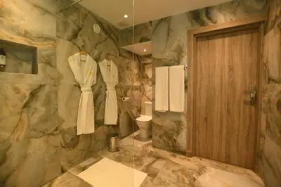 a bathroom with a stone wall with a toilet and a door at 555 Hotel Clubbing Adults Only in Marrakech