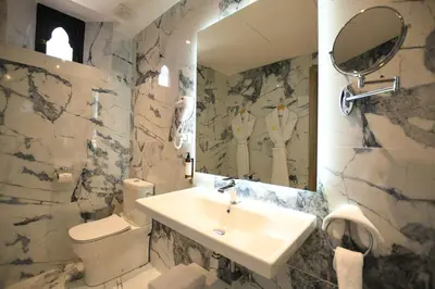 a bathroom with a sink and a toilet and a mirror at 555 Hotel Clubbing Adults Only in Marrakech