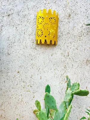 a yellow object on a wall next to a cactus at Riad privé, 5 suites et piscine in Marrakech