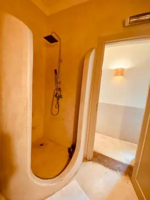 a bathroom with a shower and a glass door at Riad privé, 5 suites et piscine in Marrakech