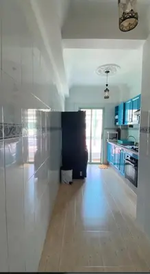 a large kitchen with white walls and a wooden floor at Charming Two-Bedroom Apartment in Marrakesh Gueliz in Marrakech
