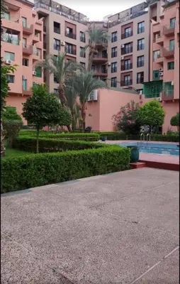 a large apartment complex with a swimming pool and a building at Charming Two-Bedroom Apartment in Marrakesh Gueliz in Marrakech
