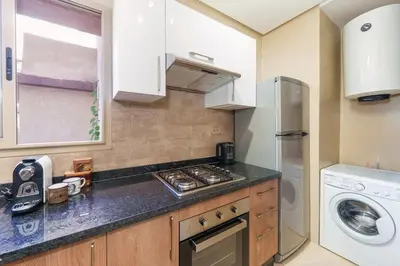 a kitchen with a stove and a refrigerator at Luxurious Apartment Marrakech with Pool, Golf, Private Garden in Marrakech
