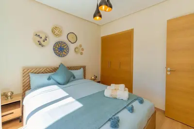 a bedroom with a large bed with blue pillows at Luxurious Apartment Marrakech with Pool, Golf, Private Garden in Marrakech