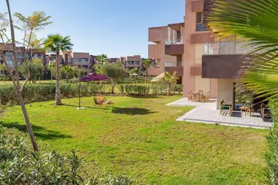 a yard in front of a building with a park at Luxurious Apartment Marrakech with Pool, Golf, Private Garden in Marrakech