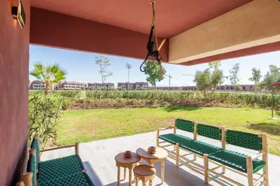 a porch with two benches and a view of a field at Luxurious Apartment Marrakech with Pool, Golf, Private Garden in Marrakech