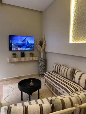 a living room with a couch and a tv at Private Riad 4 Bedrooms With Free Breakfast and Heated Plunge Pool in Marrakech