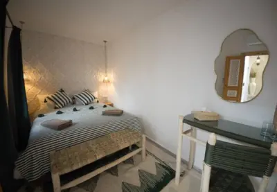 a bedroom with a bed and a table and a mirror at Private Riad 4 Bedrooms With Free Breakfast and Heated Plunge Pool in Marrakech