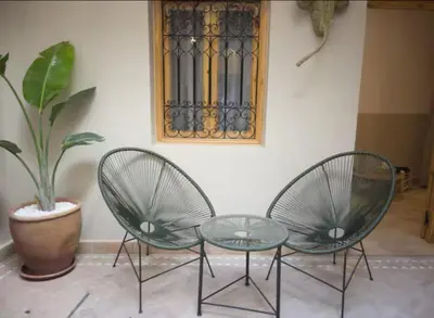two chairs and a table next to a plant at Private Riad 4 Bedrooms With Free Breakfast and Heated Plunge Pool in Marrakech