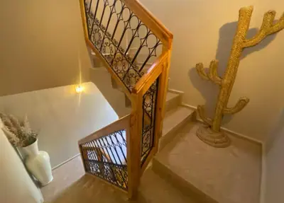 a wooden staircase with a wrought iron railing at Private Riad 4 Bedrooms With Free Breakfast and Heated Plunge Pool in Marrakech