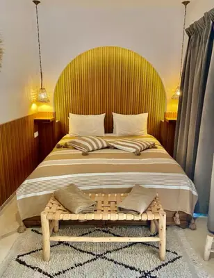 a bedroom with a large bed with a wooden headboard at Private Riad 4 Bedrooms With Free Breakfast and Heated Plunge Pool in Marrakech