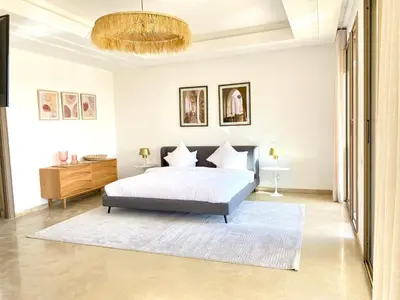 a bedroom with a bed and a chandelier at Luxury Villa Rêve D'ahlam à MARRAKECH in Oulad Boudene