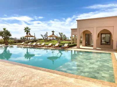 a swimming pool with chairs and a villa at Luxury Villa Rêve D'ahlam à MARRAKECH in Oulad Boudene
