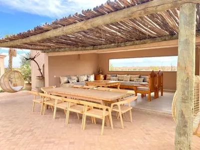 a patio with wooden tables and chairs on a patio at Luxury Villa Rêve D'ahlam à MARRAKECH in Oulad Boudene