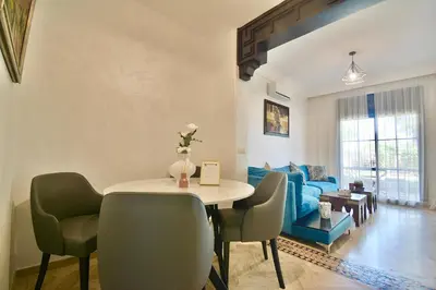 a living room with a table and chairs and a couch at Oasis de l'Atlas by Golf Resort in Marrakech