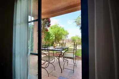 a glass door leading to a patio with a table and chairs at Oasis de l'Atlas by Golf Resort in Marrakech