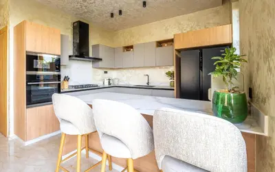 a kitchen with white chairs and a kitchen island at Villa ZINA I Luxe I Piscine chauffée I Wifi I Proche centre Ville in Marrakech