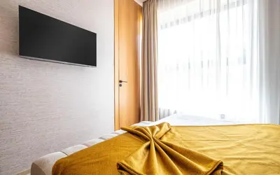 a bedroom with a bed with a television on the wall at Villa ZINA I Luxe I Piscine chauffée I Wifi I Proche centre Ville in Marrakech