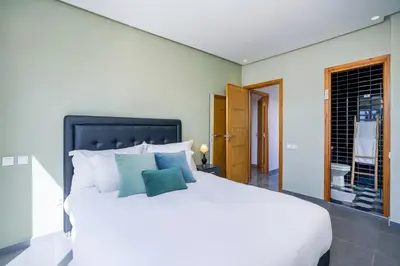 a bedroom with a large white bed with blue pillows at le petit dar alwalidine in Marrakech