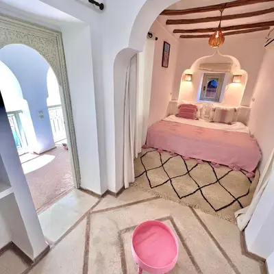 a bedroom with a bed in a room with an archway at Riad Ouatine in Marrakech