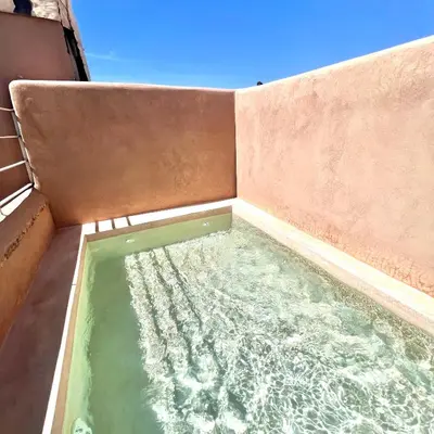 a small pool of water on the side of a building at Riad Ouatine in Marrakech