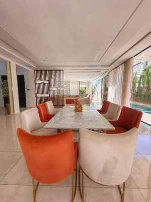 a dining room with a table and chairs at villa 105 golf noria piscine chauffée in Marrakech