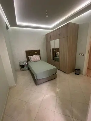 a bedroom with a bed and a wooden cabinet at Appartement calme près de Gueliz Marrakech in Marrakech