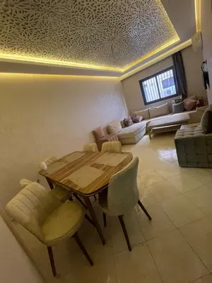 a living room with a wooden table and chairs at Appartement calme près de Gueliz Marrakech in Marrakech