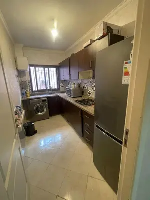 a small kitchen with a stainless steel refrigerator at Appartement calme près de Gueliz Marrakech in Marrakech