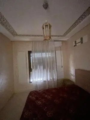 a bedroom with a bed and a window with a curtain at Appartement calme près de Gueliz Marrakech in Marrakech