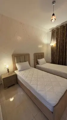 two twin beds in a bedroom with a lamp on a table at Marrakech top 1 in Marrakech