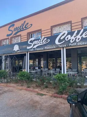 a smile smile cafe sign on the side of a building at Step into our little oasis in Marrakech