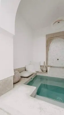 a swimming pool in a white room with at Riad KRÈME in Marrakech