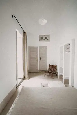 a white room with a chair and a window at Riad KRÈME in Marrakech