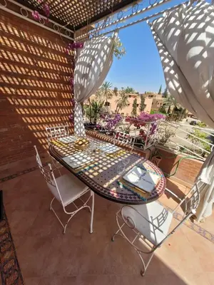 a table and chairs on a patio with an umbrella at MELBARI Cosy-Appart in Marrakech