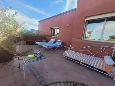a patio with a couch and chairs on a building at MELBARI Cosy-Appart in Marrakech