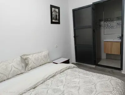 a white bedroom with a bed and a sink at Medina-in auberge in Marrakech