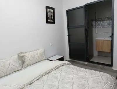 a bedroom with a white bed and a sink at Medina-in auberge in Marrakech