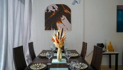 a dining room table with a vase of flowers on it at Havre de Paix à Noria Golf Marrakech in Marrakech