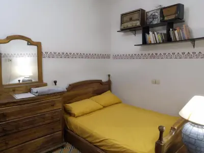 a bedroom with a bed with a dresser and a mirror at Appart 3 mins from Jamaâ el fana in Marrakech
