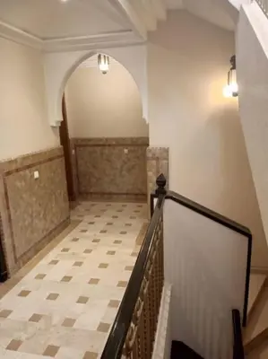 an empty hallway with a staircase and a tile floor at Le Fairouz Appartement Haut Standing centre ville Piscine in Marrakech