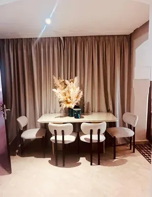 a table with chairs and a vase of flowers on it at Logement de luxe avec piscine, hivernage in Marrakech