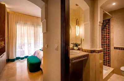 a bathroom with a sink and a bed with a window at Logement de luxe avec piscine, hivernage in Marrakech