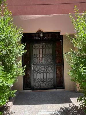 a large door to a building with at Charmant appartement spacieux avec cour fleurie et Hammam à Targa Marrakech in Marrakech