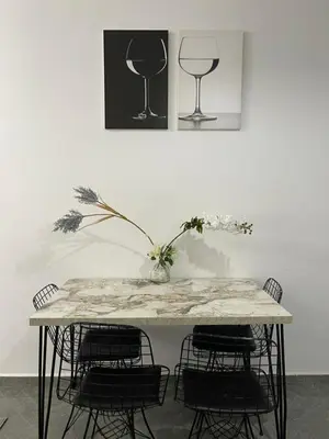 a table with chairs and a vase with flowers on it at Gueliz Marrakech Apartment 5 Min City Center in Marrakech